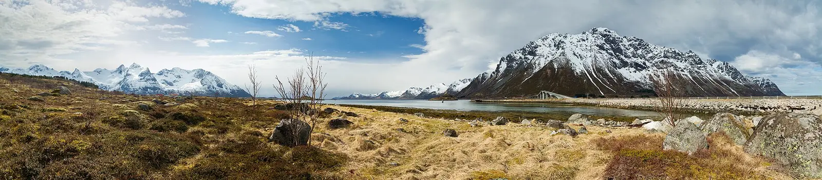 Red fishing cabins below steep peaks in Lofoten